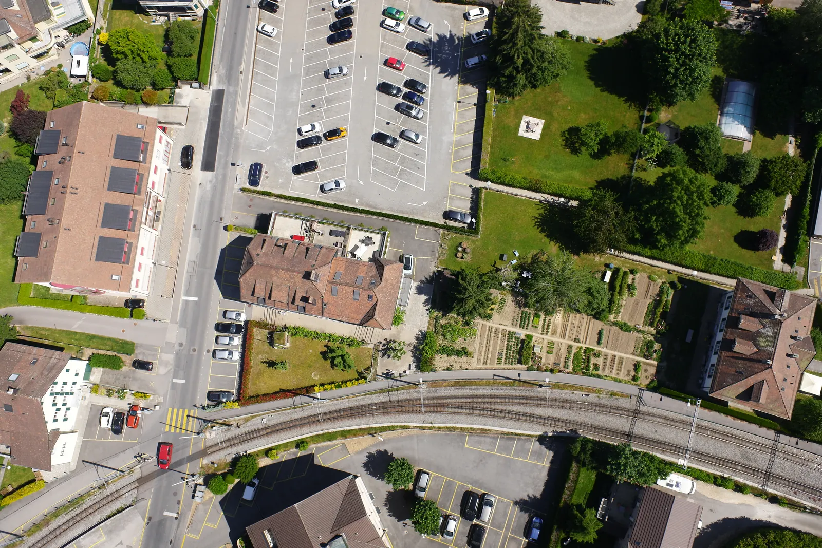 A sixth overlapping frame from the next flight line, over gardens and a car park.